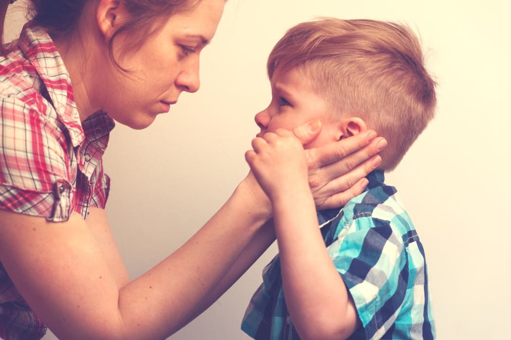 A picture of a young mother comforting little crying boy.