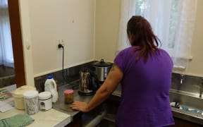 The woman, who does not want to be named, making a coffee in the emergency house.