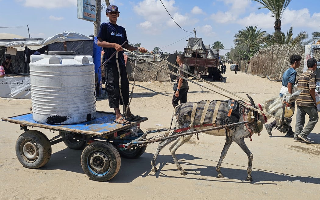 A Palestinian youth drives a cart drawn by an emaciated donkey in the Mawasi area of Rafah on July 20, 2025, as such vehicles become the main means of transport due to the scarcity of fuel in the Israel-besieged Gaza Strip. UN agencies on July 12 warned that fuel shortages had reached "critical levels", threatening to worsen conditions for Gaza's more than two million people. (Photo by AFP)