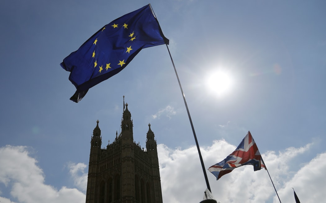 Protestor flags fly opposite the Houses of Parliament in London, Thursday, April 11, 2019.