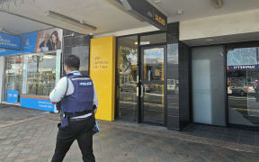 A police officer walking past an ASB ATM.
