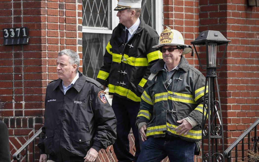 Mayor Bill de Blasio leaves the house where seven children died in a fire.