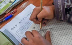 A student does homework at home in Nanchang city, east China's Jiangxi province, 11 February 2020.