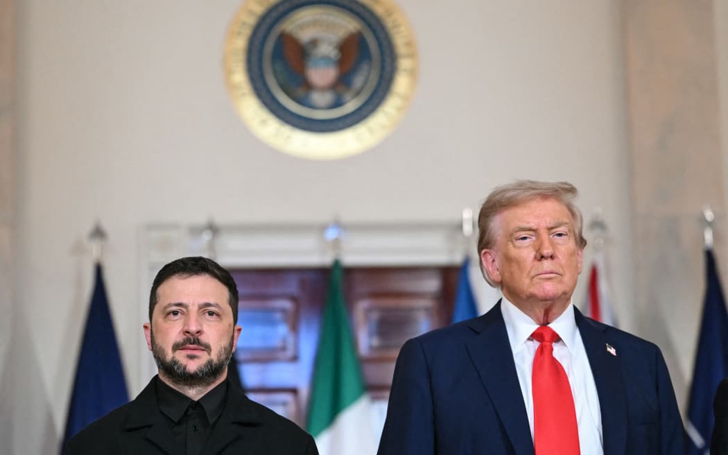 US President Donald Trump and Ukrainian President Volodymyr Zelensky stand for a family photo with European leaders in the Cross Hall of the White House in Washington, DC, on August 18, 2025. European leaders join Ukrainian President Volodymyr Zelensky in talks with US President Donald Trump on August 18, as they try to find a way to end Russia's offensive.  The leaders heading to Washington on Monday to appear alongside Zelensky call themselves the "coalition of the willing." (Photo by ANDREW CABALLERO-REYNOLDS / AFP)