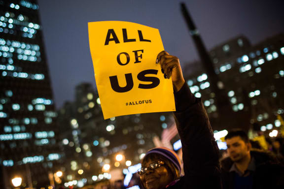 A woman waving a sign at a New York rally organised by non-unionised fast-food workers.