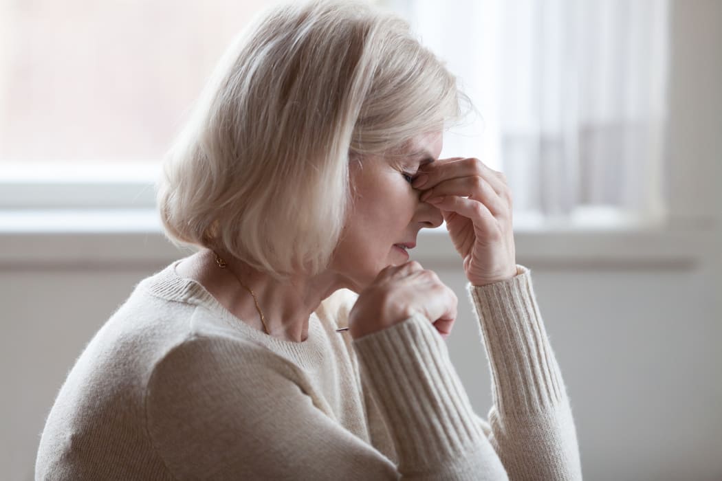 Fatigued older woman, headache, thinking, stress. (File photo)
