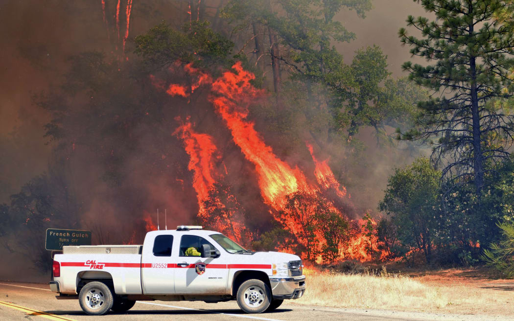 Flames engulf trees near a road during the Carr fire in Redding, California.