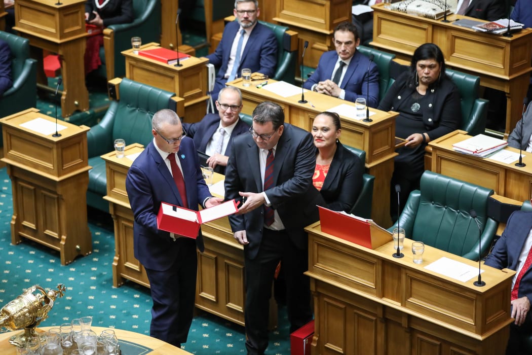 Associate Minister of Finance David Clark holds the box of budget speech copies for Minister of Finance Grant Robertson who hands a copy to each party leader.