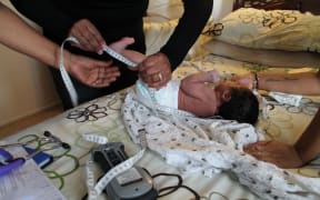 Rizwanna measures baby Jamaica