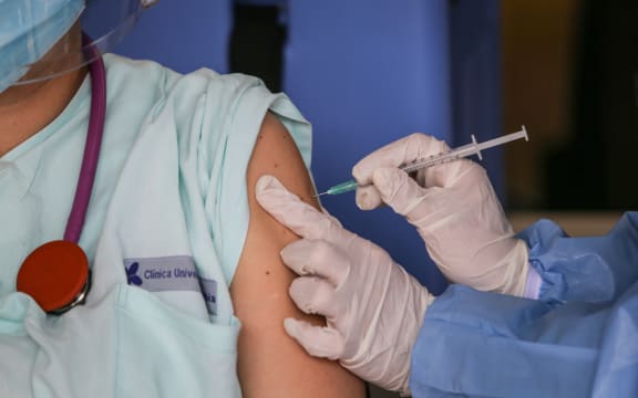 A healthcare worker injects a dose of the Pfizer-BioNTech Covid-19 vaccine to an emergency doctor in Colombia on February 18, 2021.