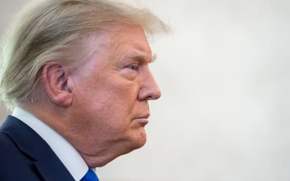 In this file photo US President Donald Trump looks on during a ceremony presenting the Presidential Medal of Freedom to wrestler Dan Gable in the Oval Office of the White House in Washington, DC on 7 December 2020. -