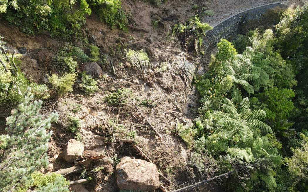A drone image captures the massive slip at Helena Bay Hill in Northland, cutting off Ōakura Bay.
