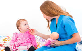 Photo of an adorable baby with her babysitter