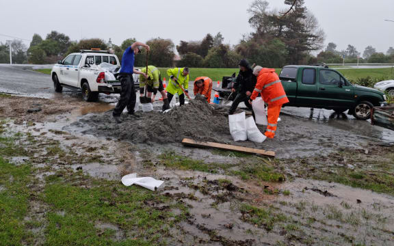Residents and Westreef personnel filling sandbags by Buller River.