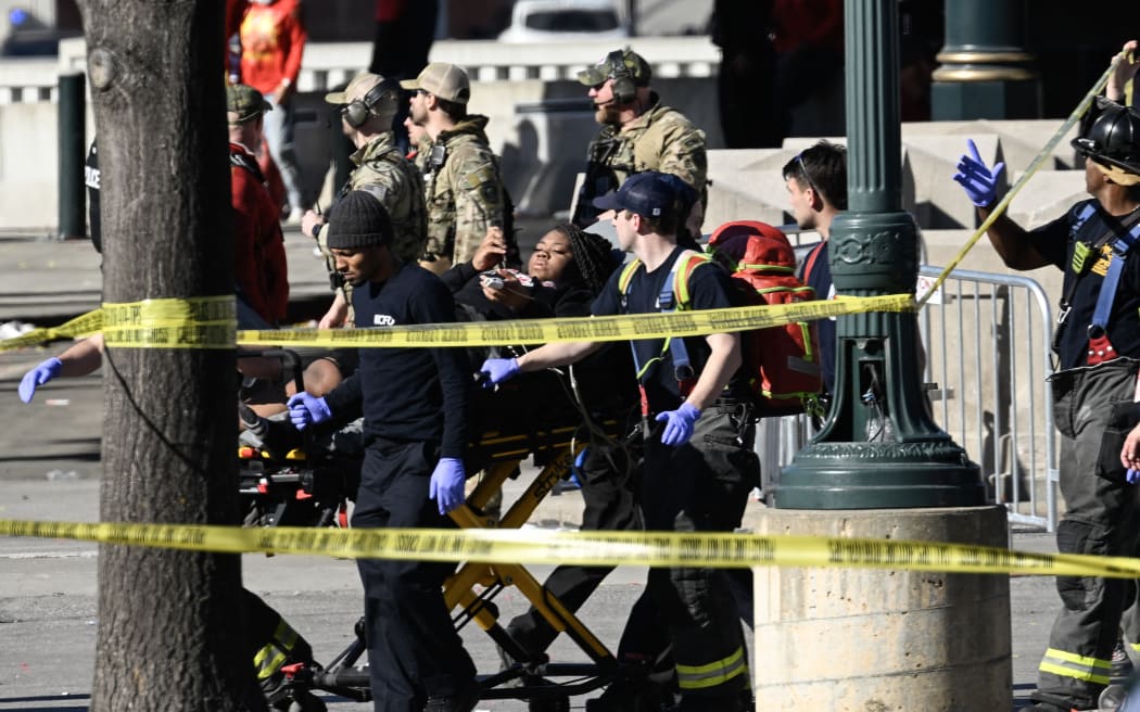 First responders tend to an injured person as they bring her out of Union Station near the Kansas City Chiefs' Super Bowl LVIII victory parade on February 14, 2024, in Kansas City, Missouri. Multiple people were injured after gunfire erupted at the Kansas City Chiefs Super Bowl victory rally on Wednesday, local police said. (Photo by ANDREW CABALLERO-REYNOLDS / AFP)