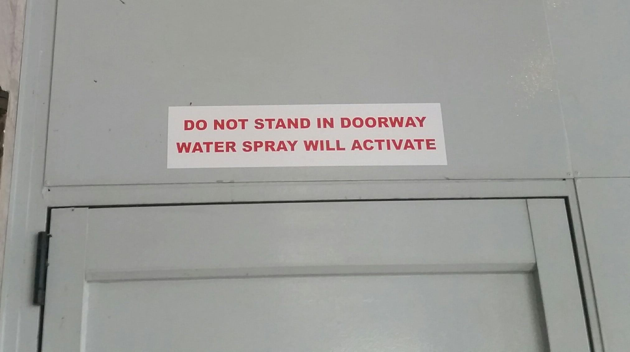 220 Queen St: A sign warns people to stay away or face sprinklers.