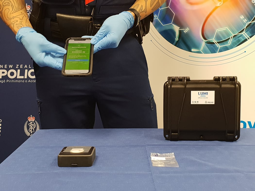 Constable Wepiha Te Kanawa showing how the new tool works. It screens through the packaging and send results to an app used exclusively by the police after connecting to ESR drug database.