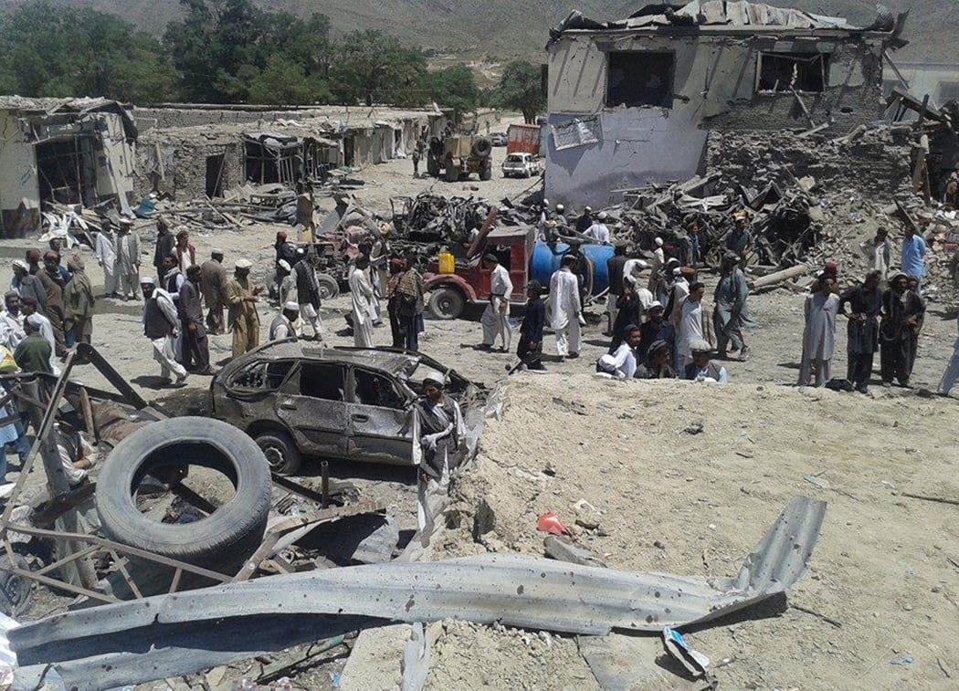 Afghans amid debris of a suicide attack at a market in Urgun district, Paktika province on July 15, 2014.
