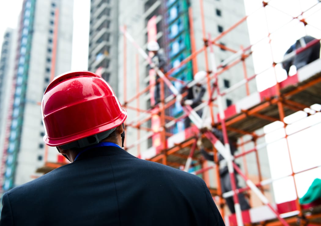Builder inspector checking a construction site works.