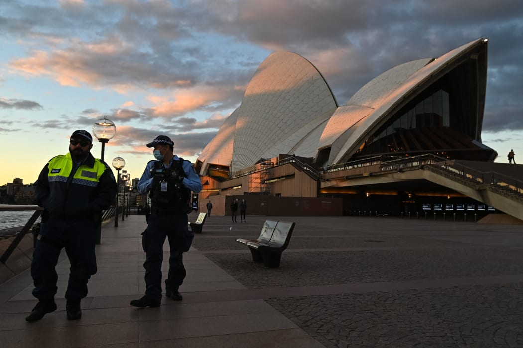 Police officers walk past The Sydney Opera House during the first day of lockdown in Sydney, Australia.
