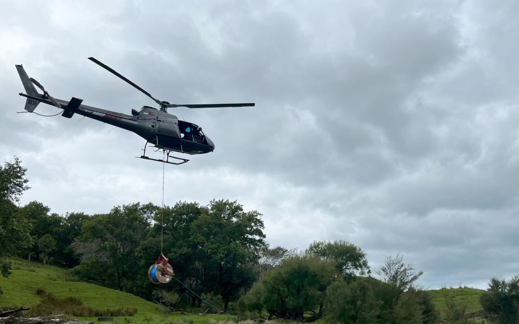A helicopter lays fibre-optic cable inland from Gisborne after Cyclone Gabrielle.