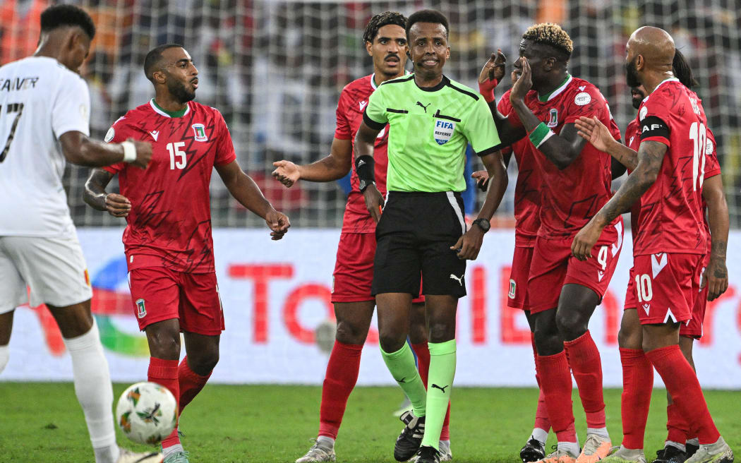 (FILES) Equatorial Guinea’s midfielder #4 Fede Bikoro (2R) speaks with Somali referee Omar Abdulkadir Artan (C) during the Africa Cup of Nations (CAN) 2024 round of 16 football match between Equatorial Guinea and Guinea at the Alassane Ouattara Stadium in Ebimpe, Abidjan, on January 28, 2024. Award-winning Somali referee Omar Artan, set to be the first from his country to officiate at the World Cup, was denied entry to the United States, a sports ministry official told AFP on June 8, 2026. 
“Denying him entry to the United States and preventing him from officiating scheduled matches harms not only him personally but also undermines football’s commitment to fairness, merit, and the spirit of fair play,” Ciise Aden Abshir, a senior advisor to Somalia’s Ministry of Youth and Sports and a former national team captain, told AFP. (Photo by Issouf SANOGO / AFP)