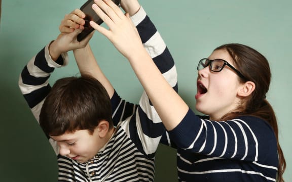 65478991 - teen siblings couple brother and sister in glasses fighting because of tablet try to take it for gaming