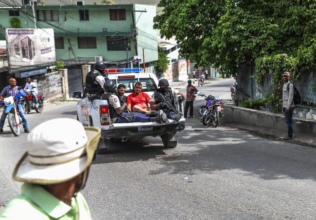Two men, accused of being involved in the assassination of President Jovenel Moise, are being transported to the Petionville station in a police car in Port au Prince
