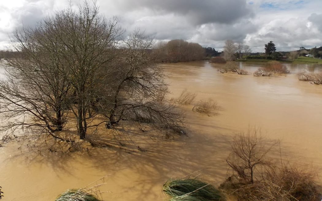 Wairoa River Tangiteroria bridge submerged by floodwaters.