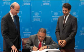 Solomon Islands Foreign Minister Peter Shanel Agovaka, middle, signing the TPNW at the UN Headquarters in New York. 24 September 2024