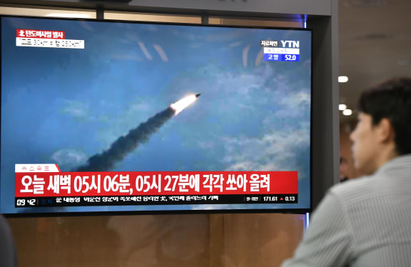 A man watches a television news screen showing file footage of a North Korean missile launch, at a railway station in Seoul on 31 July, 2019.