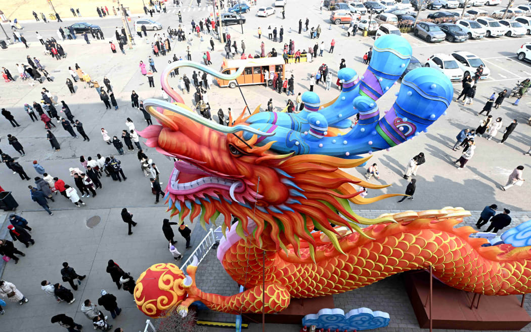 (240210) -- BEIJING, Feb. 10, 2024 (Xinhua) -- Tourists walk past a dragon-shaped installation in Shijiazhuang, north China's Hebei Province, Feb. 10, 2024. The Spring Festival falls on Feb. 10 this year. (Photo by Chen Qibao/Xinhua) (Photo by Chen Qibao / XINHUA / Xinhua via AFP)