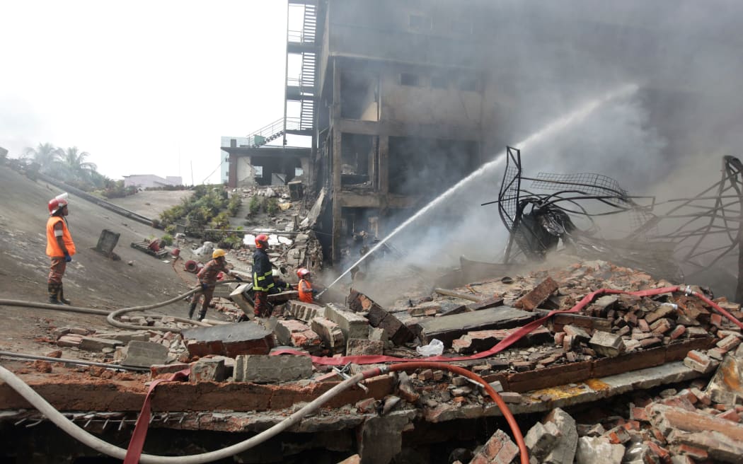 Bangladesh firefighters work to extinguish a fire that break out from an explosion in a factory in the key garment manufacturing town of Tongi, just north of the capital Dhaka.