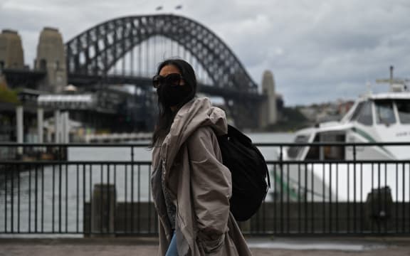 A woman walks past the Sydney Harbour Bridge after stay-at-home orders were lifted across NSW.