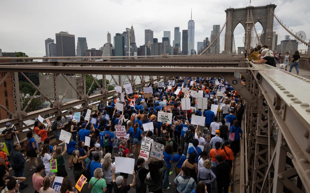 Demonstrators march across the Brooklyn Bridge during the "March for Our Lives" rally in Brooklyn, New York on June 11, 2022. - Protesters are demonstrating across the US for tighter firearms laws to curb devastating gun violence plaguing the country. (Photo by Yuki IWAMURA / AFP)