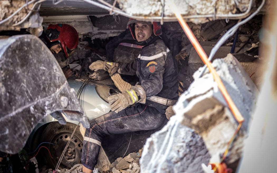 Rescue workers search for survivors in a collapsed house in Moulay Brahim, in Morocco's Al Haouz province, on 9 September, 2023.