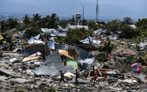 Residents walk past destroyed buildings in the Perumnas Balaroa village in Palu, after an earthquake and tsunami hit the area.