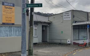 The burnt-out dairy in Alicetown on the right, and the property for sale on the left advertising 'Resource consented for 14 units'.