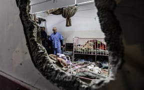 People inspect the damage in a room following Israeli bombardment at Nasser Hospital in Khan Yunis in the southern Gaza Strip on December 17, 2023, amid ongoing battles between Israel and the Palestinian militant group Hamas. (Photo by STRINGER / AFP)