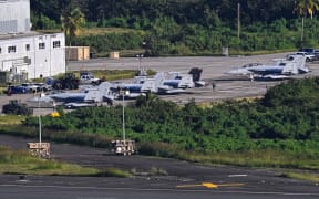 US Navy Boeing EA-18G Growlers sit on on the tarmac at José Aponte de la Torre Airport, formerly Roosevelt Roads Naval Station, on December 15, 2025 in Ceiba, Puerto Rico. Aircraft movements and coordinated exercises were observed throughout the day as part of heightened regional military readiness linked to ongoing operations at US military bases and maritime security efforts in the Caribbean. President Donald Trump administration is conducting a military campaign in the Caribbean and eastern Pacific, deploying naval and air forces for what it calls an anti-drugs offensive. (Photo by Miguel J. Rodriguez Carrillo / AFP)