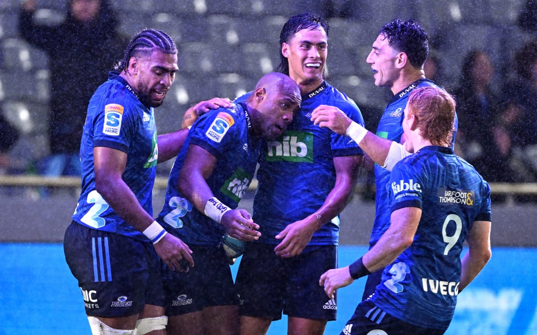 Mark Tele'a of the Blues celebrates his try with teammates.