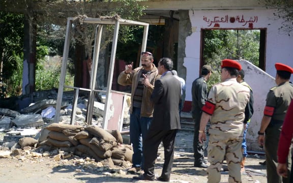 Egyptian soldiers and officials inspect the Cairo checkpoint where gunment killed six soldiers.
