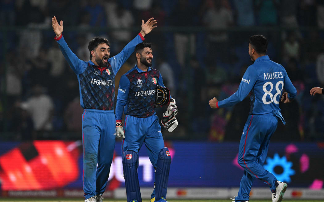 Afghanistan's Rashid Khan and team-mates celebrate on their way to beating England at the 2023 World Cup.