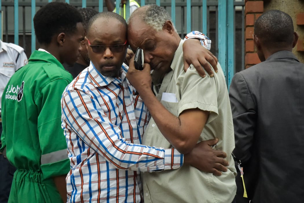 A man in the arms of a relative identifying the bodies of victims of the attack on DusitD2 luxury hotel complex in Nairobi, Kenya.