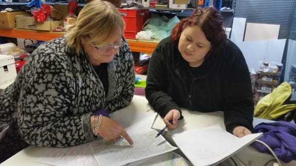 Karen Quak (left) and Robyn Rust coordinate what streets to search next.