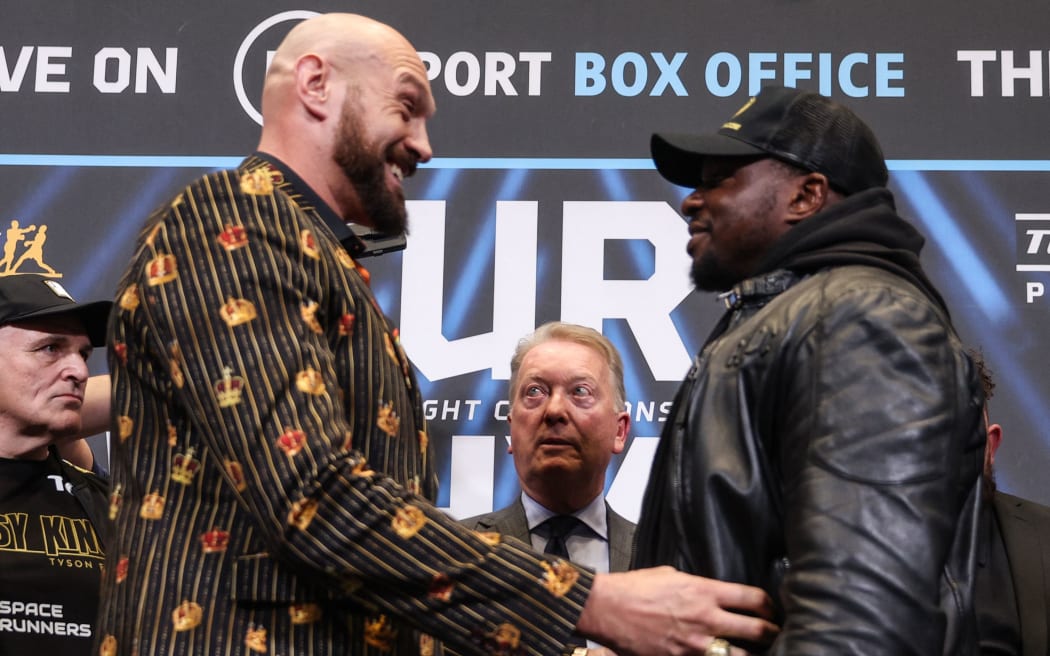 World Boxing Council (WBC) heavyweight title holder Britain's Tyson Fury tickles his compatriot Dillian Whyte as they meet during a pre-fight press conference at Wembley Stadium  2022.