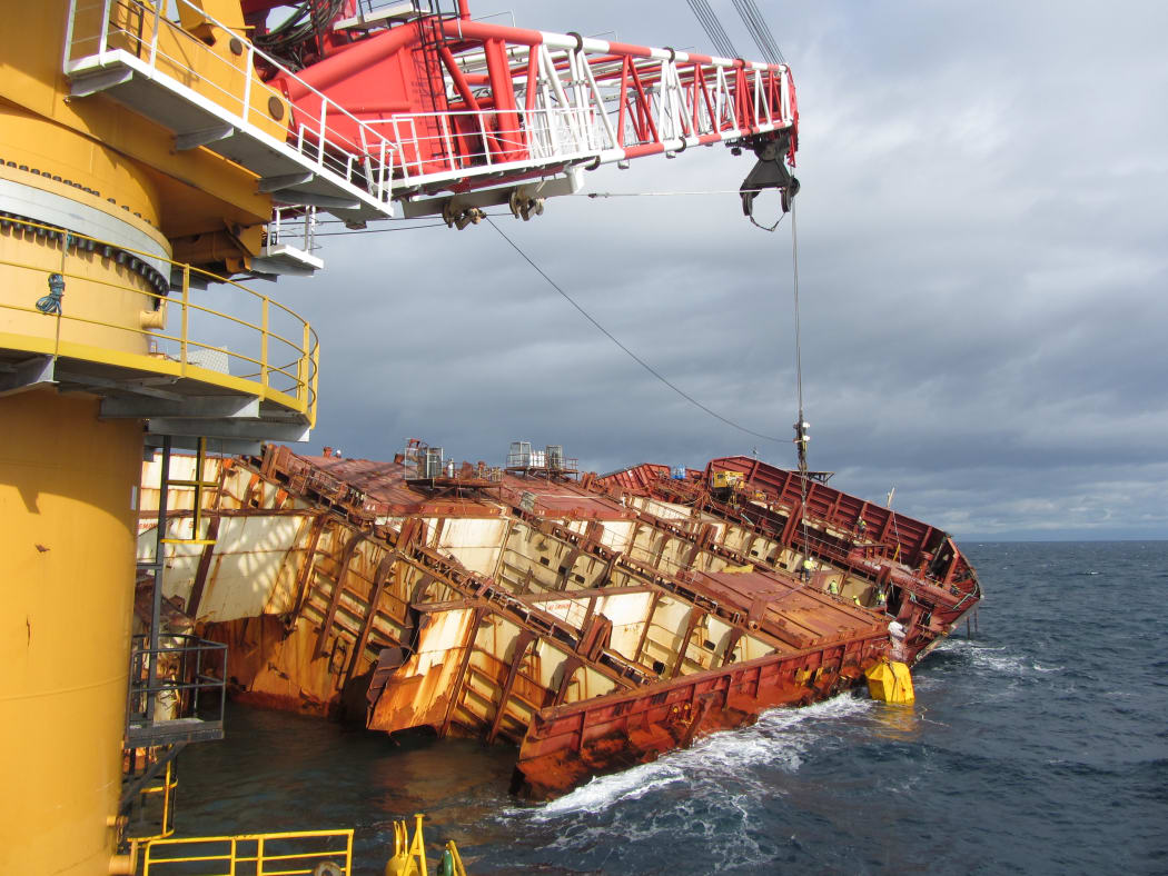 Salvage cranes working on the Rena in May.