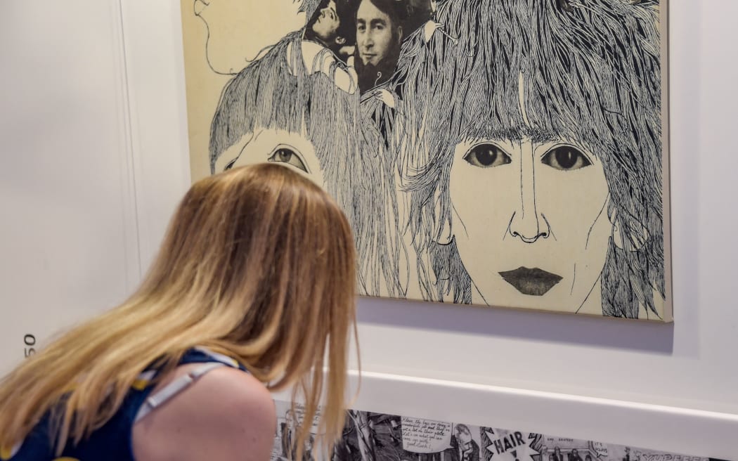 20 September 2018, Hamburg: A visitor to the Reeperbahn Festival sees in the exhibition: "Klaus Voormann - It all starts in Hamburg" the album cover of the English band Beatles' album "Revolver" by Voormann, known as the fifth Beatle. The music festival will take place from 19 to 22 September in the Hanseatic city. Photo: Axel Heimken/dpa (Photo by AXEL HEIMKEN / DPA / dpa Picture-Alliance via AFP)
