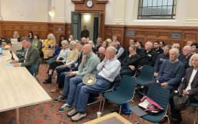 Olympic Pools director, Peter Rust, surrounded by supporters speaking to the Waitematā Local Board's at its August meeting.