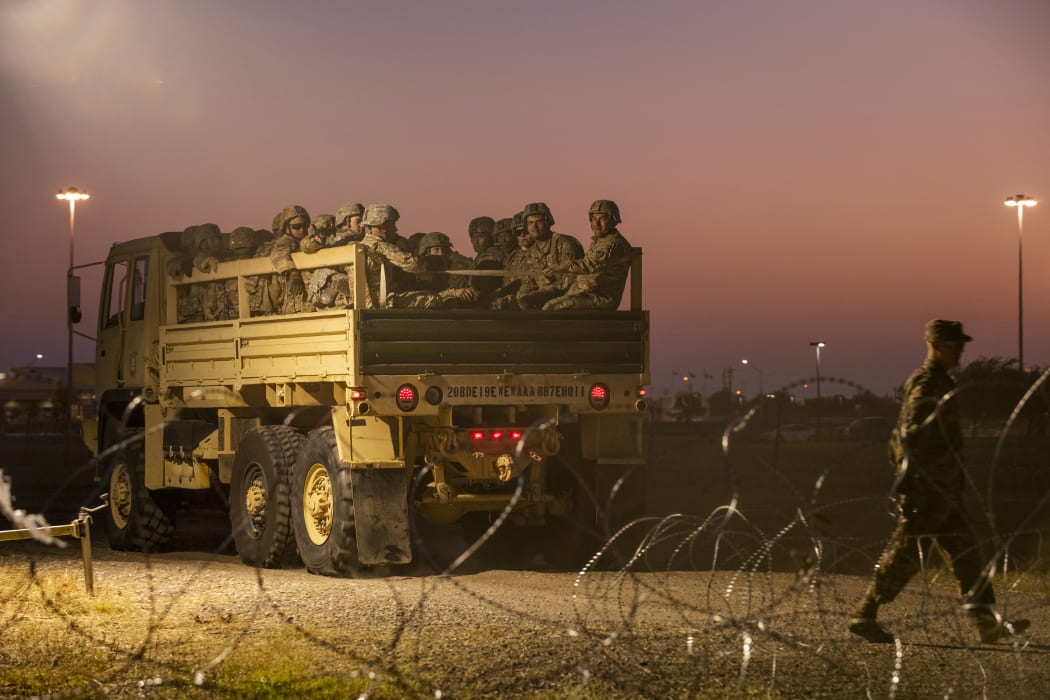 US Army troops enter a compound where the military is erecting an encampment near the US-Mexico border crossing at Donna, Texas.